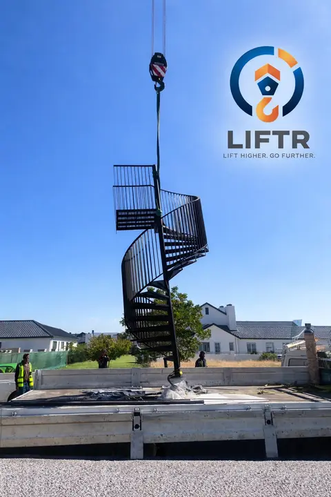 Spiral staircase being lowered into a garden